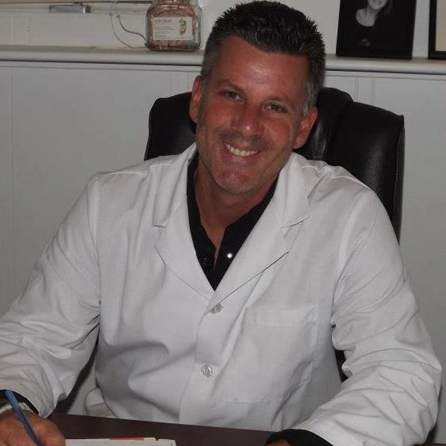 Dr. Craig Scarpelli smiling in his Brick chiropractic office